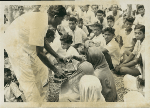 Priest Junesh Raika serves communion to an RLDS congregation in Odisha, India, ca. 1968; image courtesy of Community of Christ Archives.
